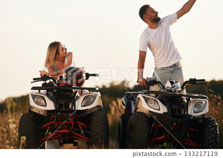 Making a selfie. Man and woman are on ATV outdoors Making a selfie. Man and woman are on ATV outdoors 133217119