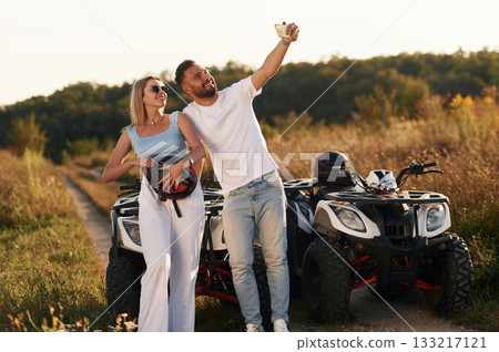 Making a selfie. Man and woman are on ATV outdoors 133217121