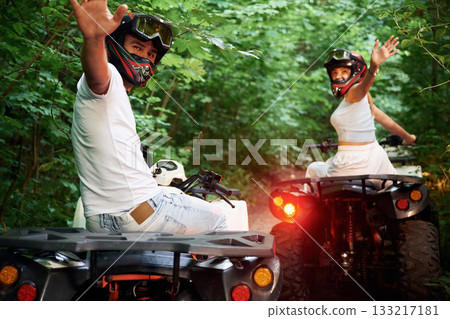 In the forest. Man and woman are on ATV outdoors 133217181