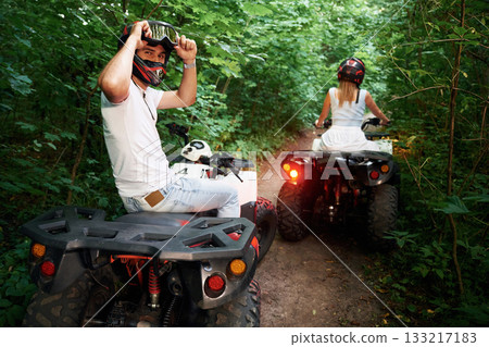 In the forest. Man and woman are on ATV outdoors 133217183