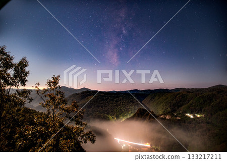 A mystical mist covering the valley and a starry sky above the mountains A mystical mist covering the valley and a starry sky above the mountains 133217211