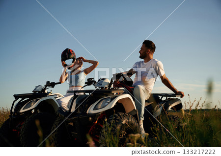 Rest time, sitting and taking a break. Man and woman are on ATV outdoors Rest time, sitting and taking a break. Man and woman are on ATV outdoors 133217222