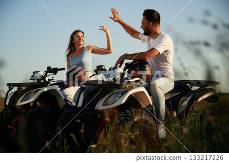 Rest time, sitting and taking a break. Man and woman are on ATV outdoors 133217226