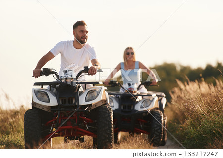On the open rural road. Man and woman are on ATV outdoors 133217247