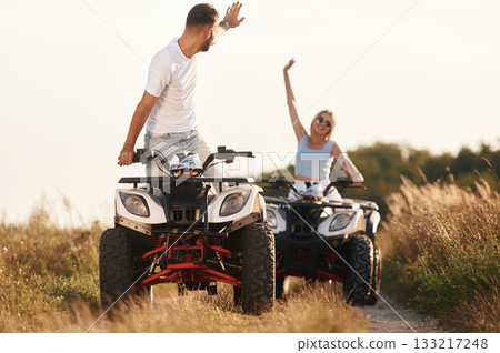 On the open rural road. Man and woman are on ATV outdoors 133217248