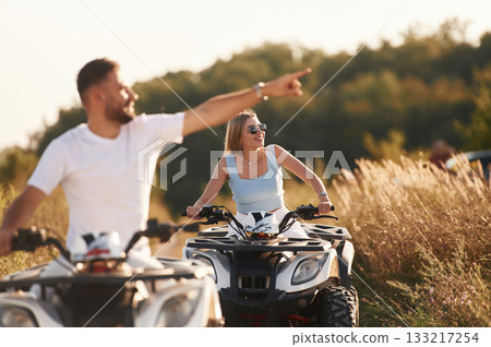 Cheerful facial expression. Man and woman are on ATV outdoors 133217254