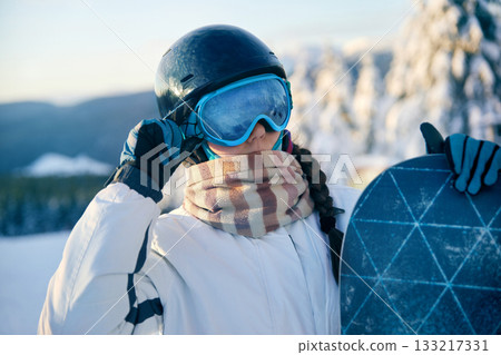 Portrait Of Woman Holding a Snowboard And Wearing Ski Glasses. Portrait Of Woman Holding a Snowboard And Wearing Ski Glasses. 133217331