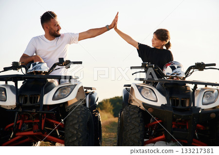 High five gesture. Father and daughter are with ATV outdoors High five gesture. Father and daughter are with ATV outdoors 133217381