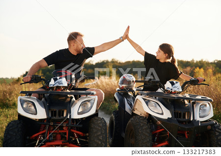 High five gesture. Father and daughter are with ATV outdoors 133217383