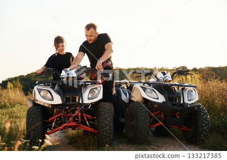 Showing how the machine works. Father and daughter are with ATV outdoors 133217385