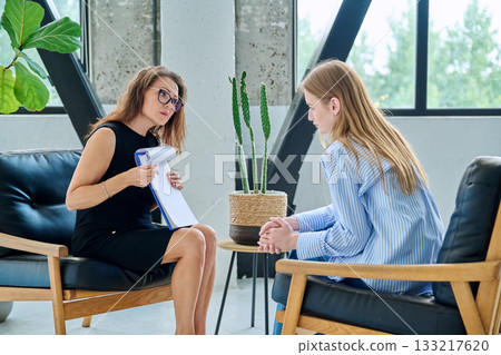 Middle aged professional female psychologist, counselor working with young woman 133217620