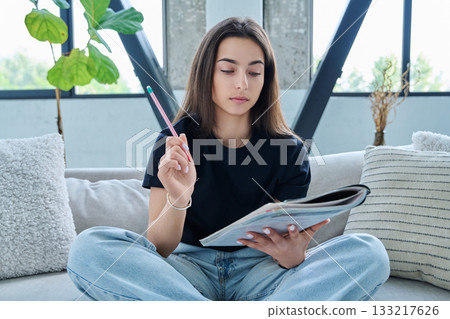 Webcam view of teenage girl student with textbook studying online remotely, video lesson Webcam view of teenage girl student with textbook studying online remotely, video lesson 133217626