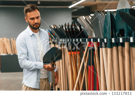 Selecting the new equipment. Man is in the hardware shop Selecting the new equipment. Man is in the hardware shop 133217651