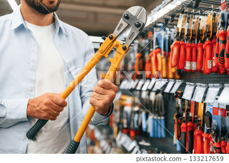 With garden shears. Man is in the hardware shop With garden shears. Man is in the hardware shop 133217659