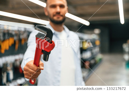 Selecting the new equipment. Man is in the hardware shop 133217672