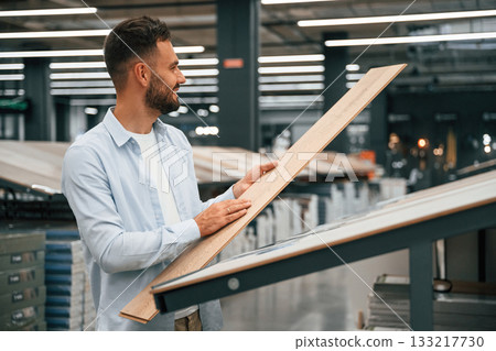 Parquet, choosing. Man is in the hardware shop Parquet, choosing. Man is in the hardware shop 133217730