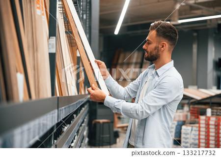 Parquet, choosing. Man is in the hardware shop Parquet, choosing. Man is in the hardware shop 133217732