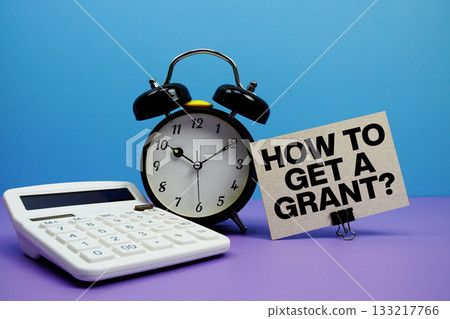 How To Get A Grant? text with calculator and alarm clock on blue and purple background 133217766