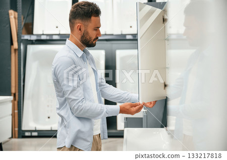 Bathroom goods. Man is in the hardware shop 133217818