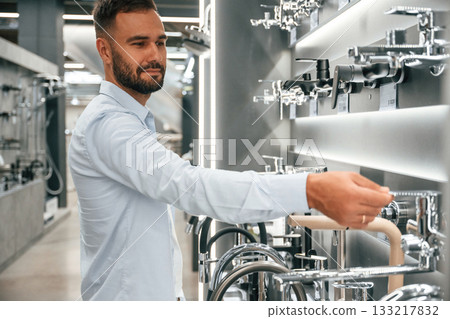 In a room with plumbing equipment. Man is in the hardware shop 133217832