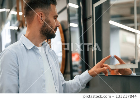 Smart mirror, touching it. Man is in the hardware shop Smart mirror, touching it. Man is in the hardware shop 133217844