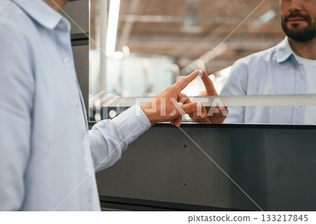 Touching, trying smart mirror. Man is in the hardware shop 133217845
