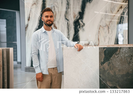 Creamy colored tiles for bathroom. Man is in the hardware shop Creamy colored tiles for bathroom. Man is in the hardware shop 133217863