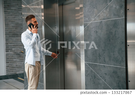 Man in formal clothes is indoors, elevator 133217867