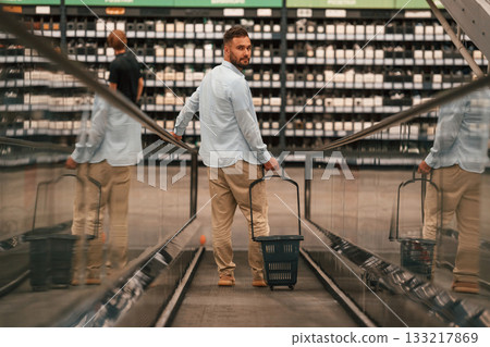 Customer is on the way. Handsome man is on the escalator in the mall 133217869