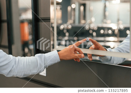 Close up view, touching smart mirror. Man is in the hardware shop 133217895
