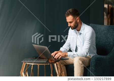 Businessman is sitting and working by using laptop Businessman is sitting and working by using laptop 133217899