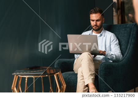 Businessman is sitting and working by using laptop Businessman is sitting and working by using laptop 133217900