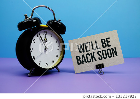 We'll Be Back Soon text with alarm clock on blue and purple background 133217922
