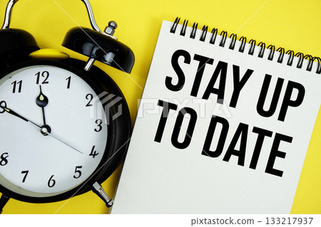 Stay Up To Date text with alarm clock flat lay on yellow background Stay Up To Date text with alarm clock flat lay on yellow background 133217937