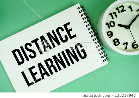 Distance Learning text with alarm clock flat lay on green background 133217948