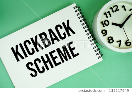 kickback schemes text with alarm clock flat lay on green background 133217949