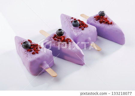 With blueberries. Cheesecake that looks like ice cream. Against white background With blueberries. Cheesecake that looks like ice cream. Against white background 133218077