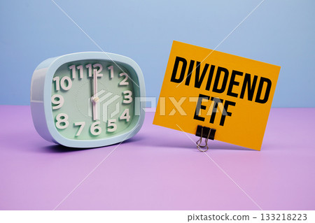 Dividend ETF text and alarm clock on blue and purple background Dividend ETF text and alarm clock on blue and purple background 133218223