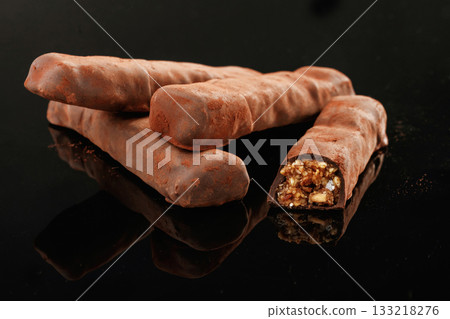 Crispy and sweet chocolate bars on black background Crispy and sweet chocolate bars on black background 133218276
