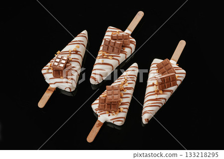In the form of ice cream. Tasty cheesecakes on the black background In the form of ice cream. Tasty cheesecakes on the black background 133218295