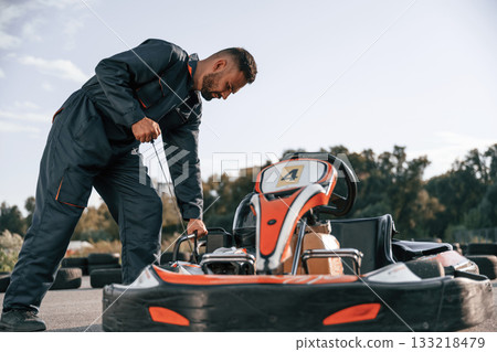 Starting the vehicle. Man is outdoors, kart racing conception 133218479