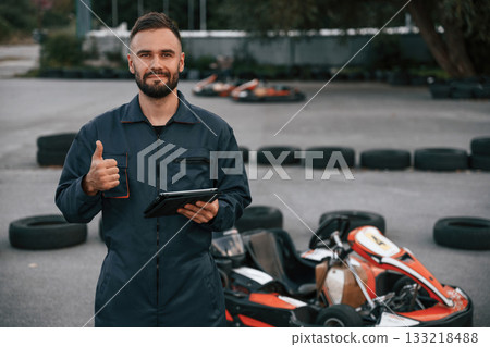 Digital tablet, quality control. Man is outdoors, kart racing conception 133218488