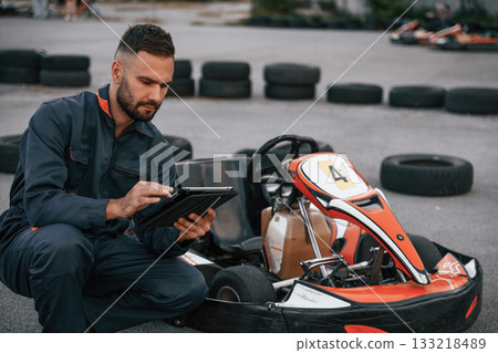 Digital tablet, quality control. Man is outdoors, kart racing conception 133218489