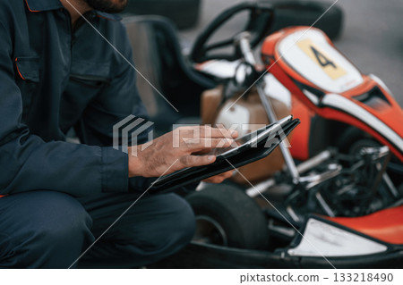 Digital tablet, quality control. Man is outdoors, kart racing conception 133218490