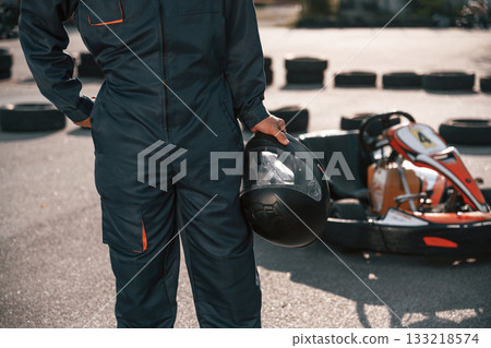 Close up view, holding safety helmet. Man is outdoors, kart racing conception Close up view, holding safety helmet. Man is outdoors, kart racing conception 133218574
