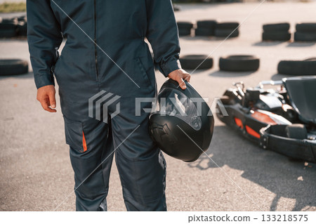 Close up view, holding safety helmet. Man is outdoors, kart racing conception Close up view, holding safety helmet. Man is outdoors, kart racing conception 133218575