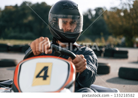 Front view, driving. Man is outdoors, kart racing conception 133218582