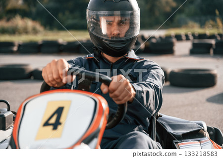 Front view, driving. Man is outdoors, kart racing conception 133218583