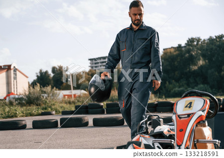 Walking by the vehicle. Man is outdoors, kart racing conception 133218591