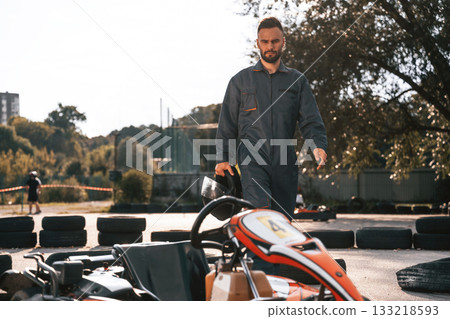 Walking by the vehicle. Man is outdoors, kart racing conception 133218593